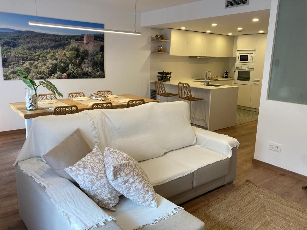 圣科洛马·德法尔Apartamento céntrico, climatizado y totalmente equipado de 3 habitaciones para 6-7 personas的一间带白色沙发的客厅和一间厨房