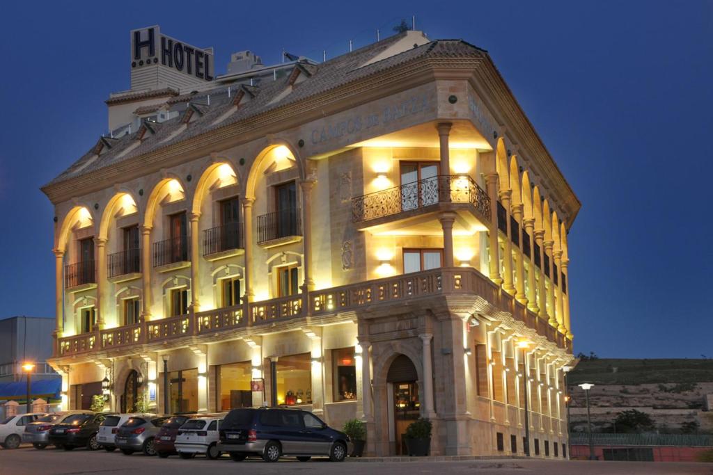 巴埃萨巴埃萨坎普斯酒店的一座大型建筑,前面有汽车停放