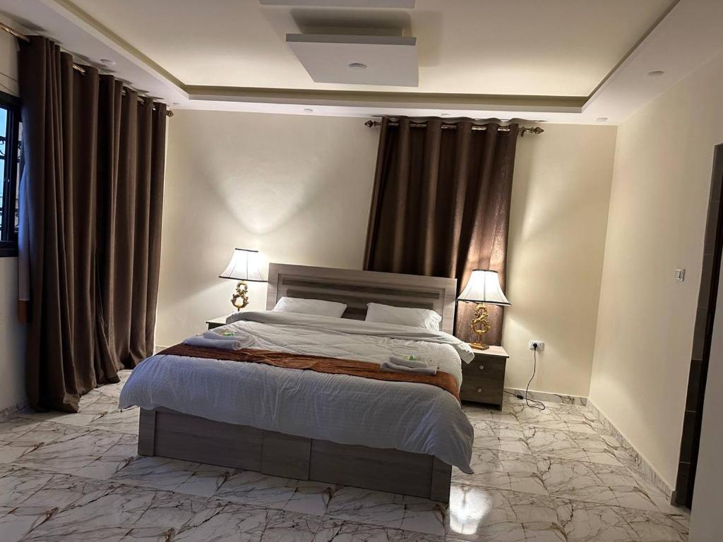 杰拉什Dream house hotel jerash的一间卧室配有一张床和两盏灯及窗帘
