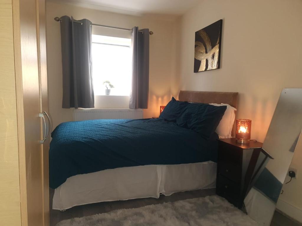 伦敦One Bedroom Apartment with Garden的一间卧室配有一张带蓝色棉被的床和窗户。