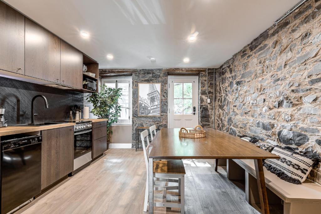 魁北克市Beautiful Vieux 2 Bedroom Apt的厨房配有桌子和石墙