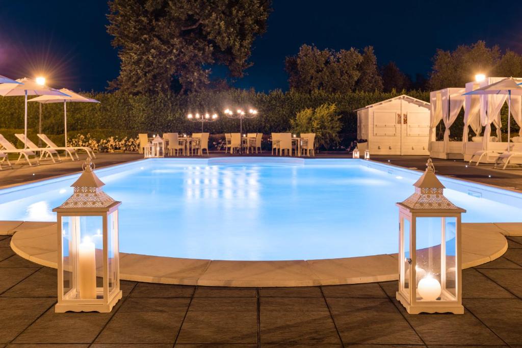 维泰博Alla Corte Delle Terme Resort的夜间大型游泳池,灯光照亮