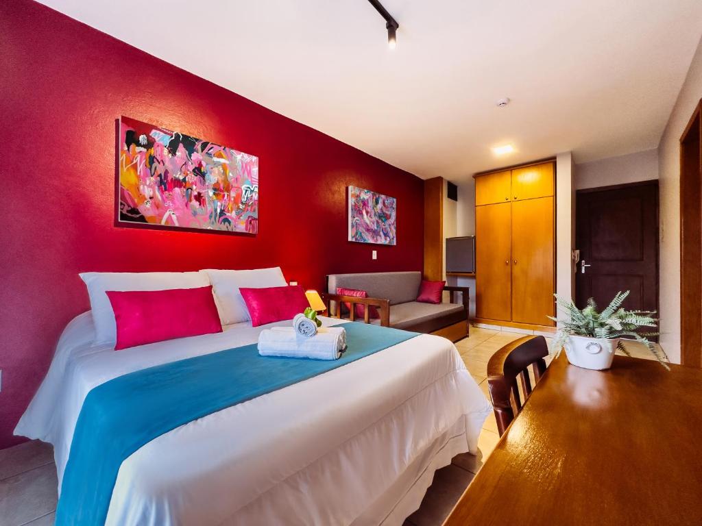 卡内拉Luzzy Hotel的一间卧室设有一张红色墙壁的大床
