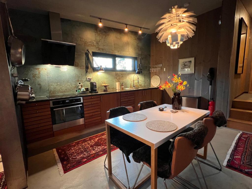 特罗姆瑟Håkøya Lodge的厨房配有桌椅和吊灯。