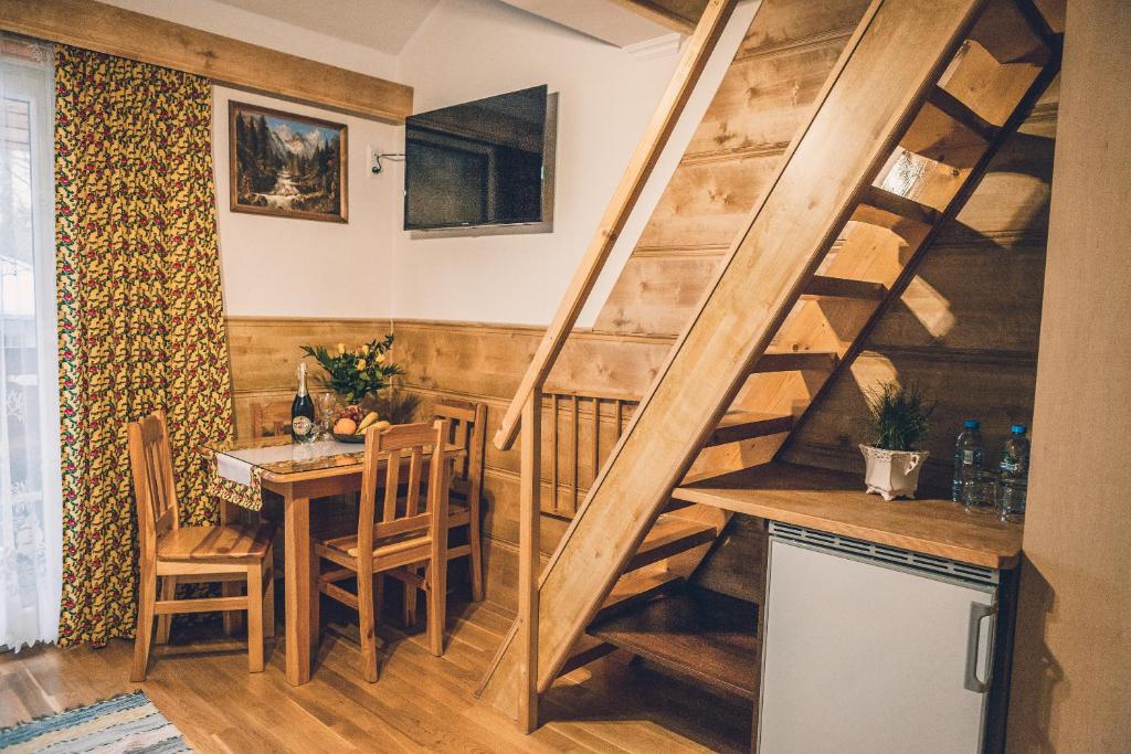 拉布卡Willa Szarotka的厨房以及带木楼梯和桌子的用餐室。