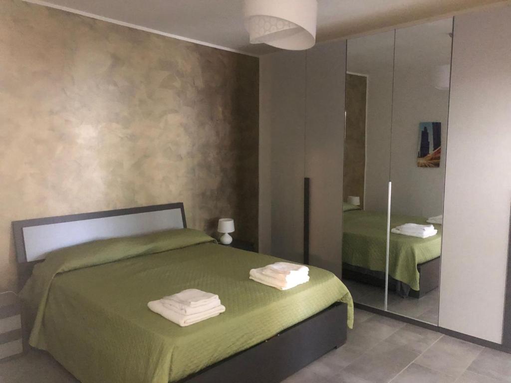 奥尔巴萨诺La Maison di Aurora的一间卧室配有绿色的床和镜子
