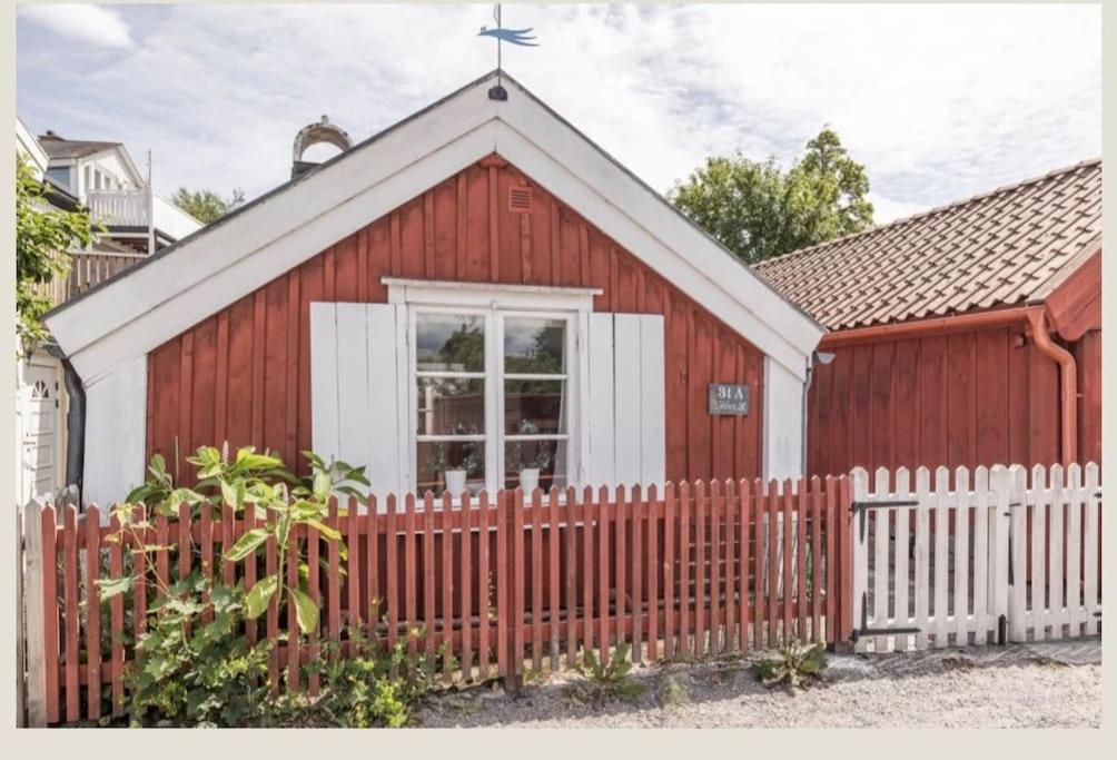 卡尔马Historisk Charm i Hjärtat av Gamla Stan Kalmar的红白色的教堂,有栅栏
