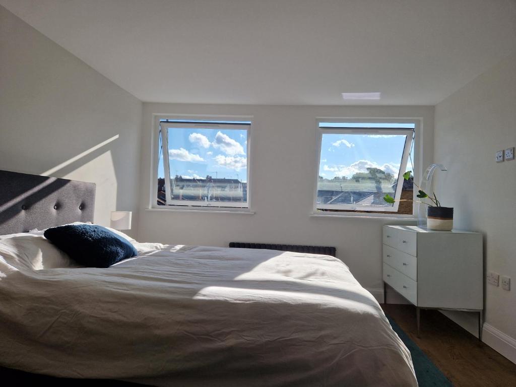 伦敦Luxury London Oasis的一间卧室设有一张大床和两个窗户。