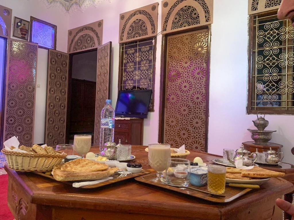 梅克内斯Riad Sibari的一张桌子,上面有面包和饮料
