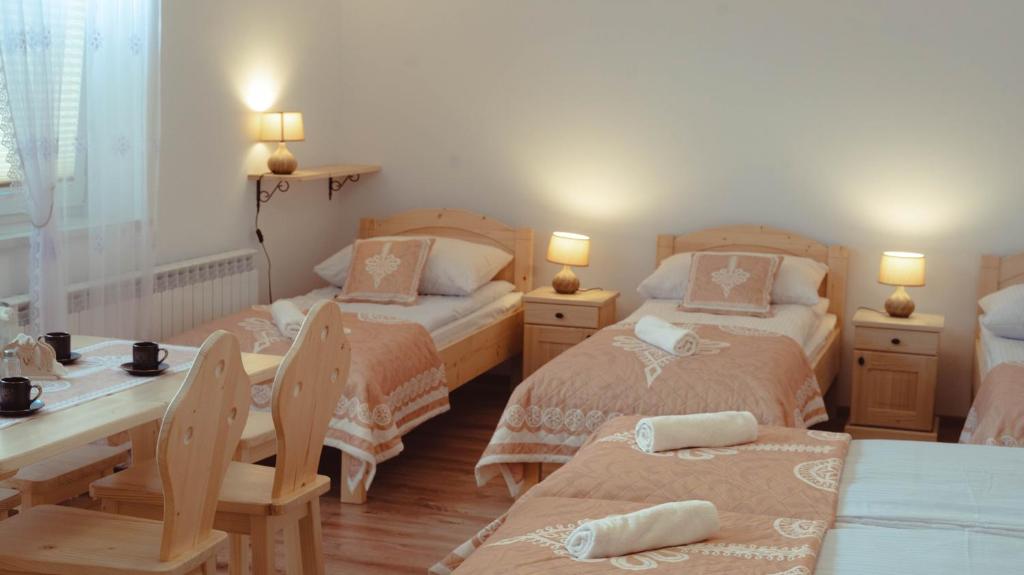 Poręba WielkaNoclegi i Agroturystyka Dorota Rusnak的一间卧室配有两张床和一张桌子及椅子