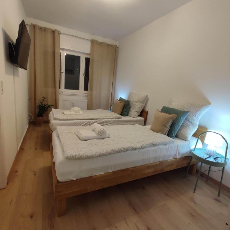 普福尔茨海姆Praktisch und Gut in der Goldstadt的一间卧室配有两张床和电视。