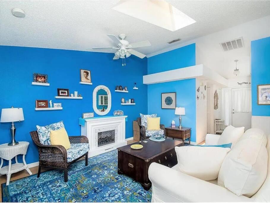 塔彭斯普林斯Charming Vintage Haven的客厅设有蓝色的墙壁和吊扇。
