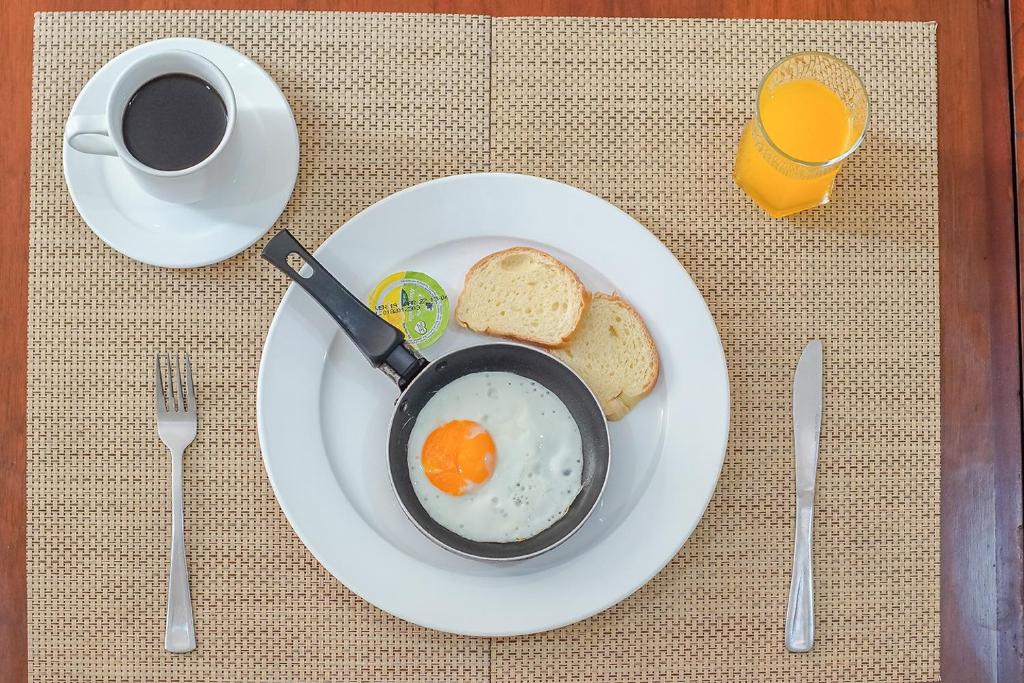 帕斯托Ayenda Hotel Posada Leon的盘子,盘子上放着一碗鸡蛋和面包,还有一杯咖啡