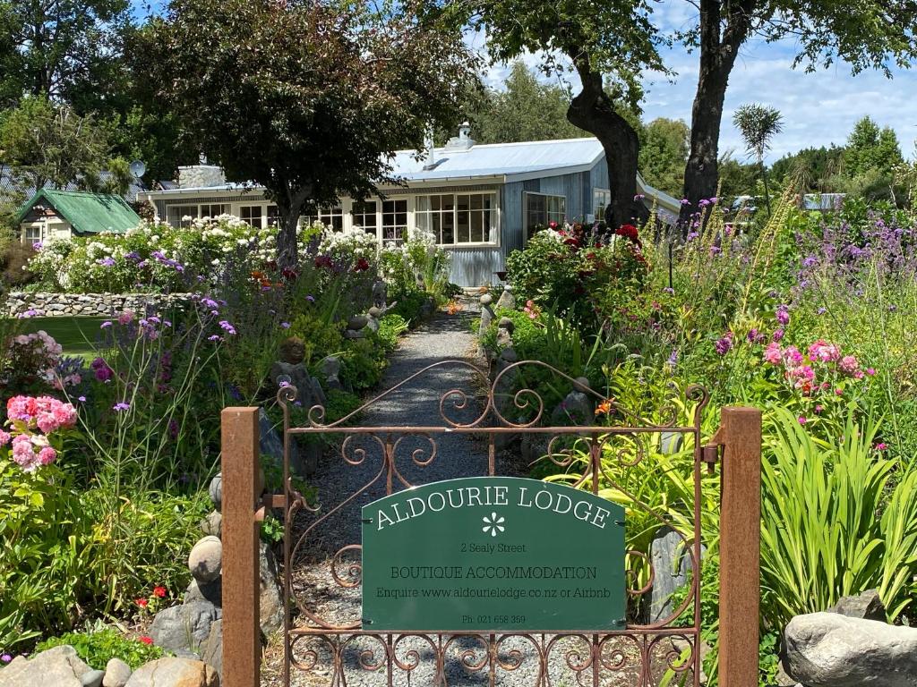 特卡波湖Aldourie Lodge的房屋前带迎宾标志的花园