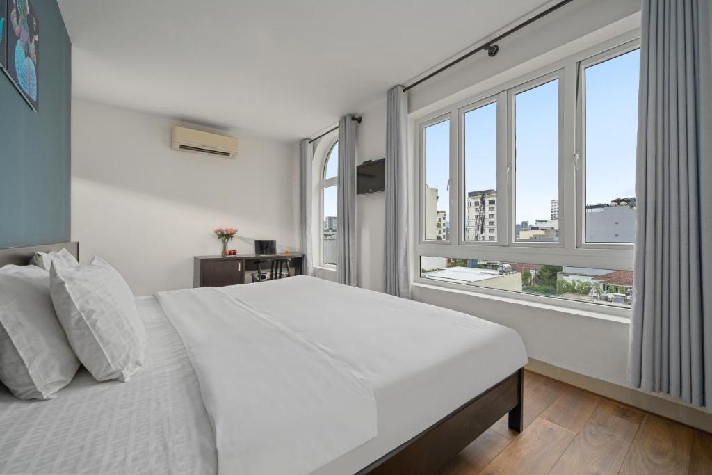 岘港Gold Time Hotel Da Nang的白色卧室设有大床和窗户