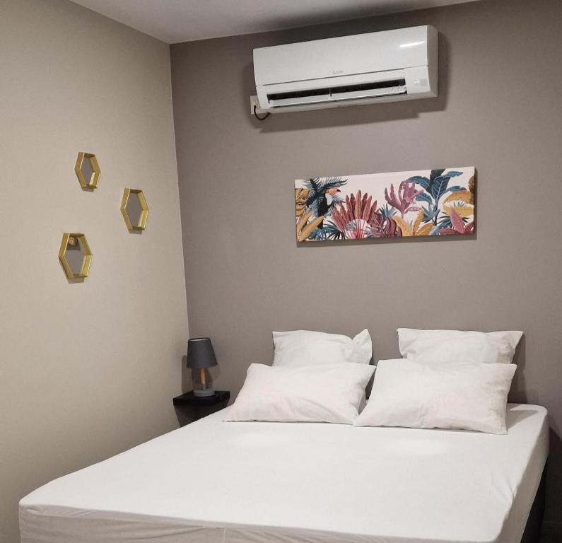 马罗尼河畔圣洛朗JEALYA TOURISTIQUES的卧室配有白色的床和空调