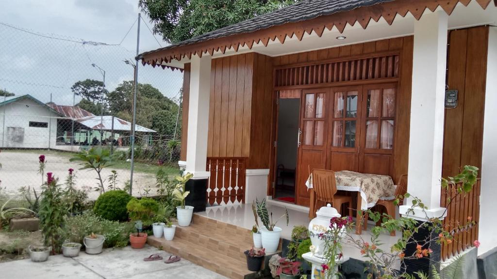 PasarbaruHomestay Suryati Tanjong Tinggi的一座带木门和一束盆栽植物的房子