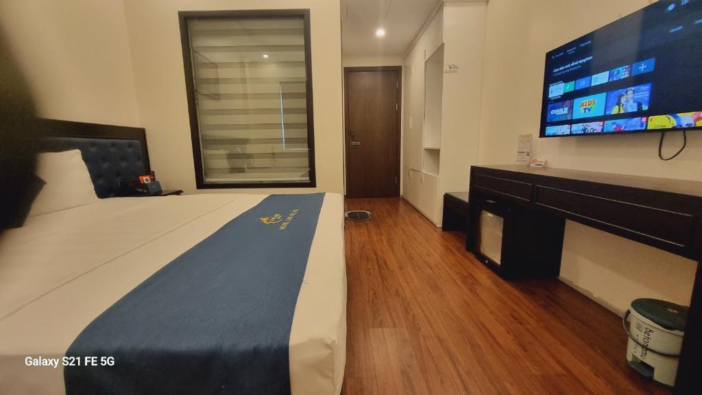 下龙湾Sao Việt HTH Hotel的一间卧室配有一张大床和一台大电视