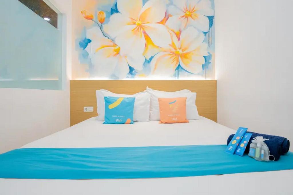 Wonokitri 2Sans Hotel Box Mansion Surabaya by RedDoorz的一间卧室配有蓝色和橙色枕头的床