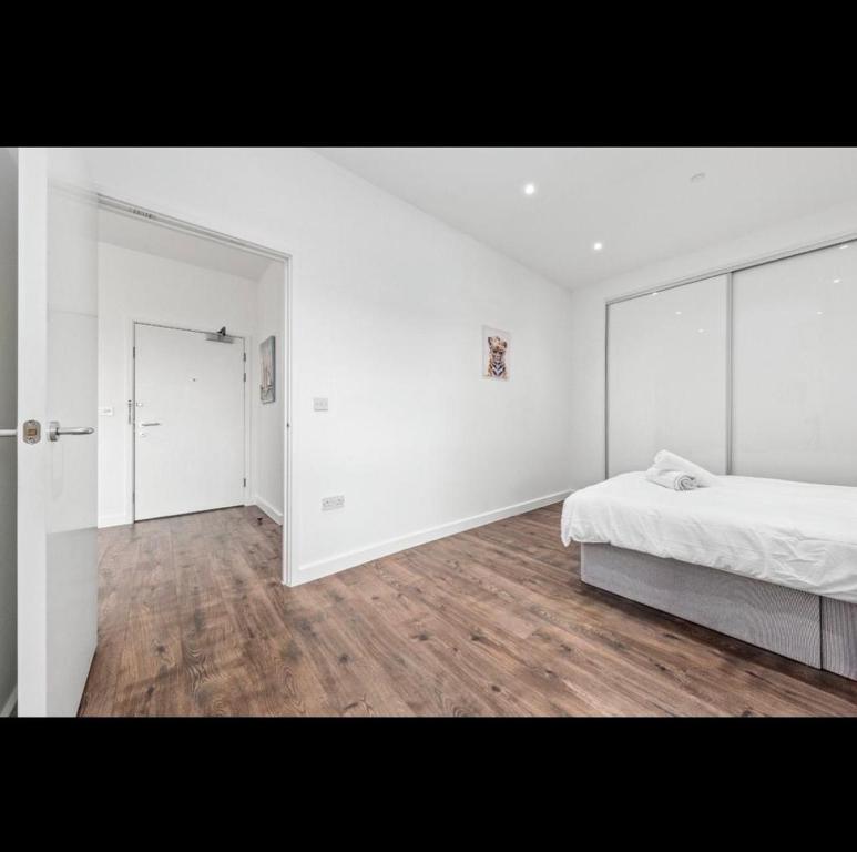 巴塞尔顿Charming 1 Bedroom Flat in Essex TH620的白色卧室设有床和大镜子