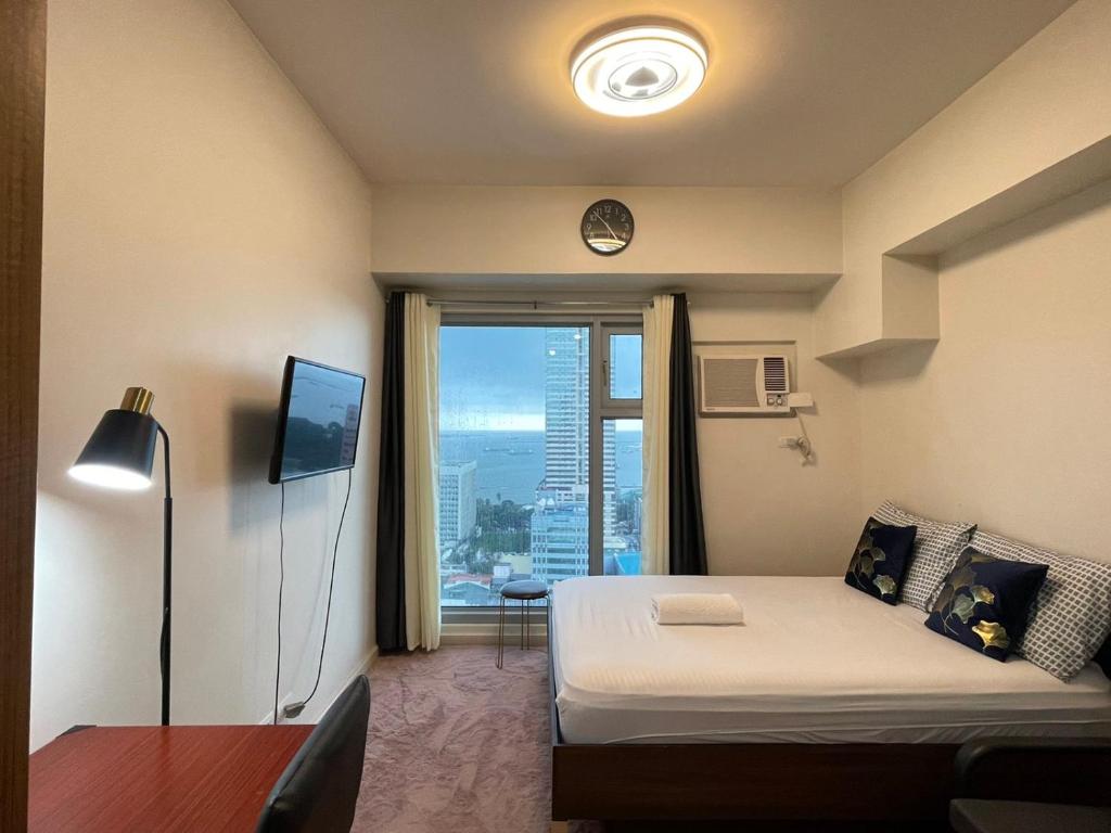 马尼拉8 Adriatico的一间卧室设有一张床和一个美景窗户。