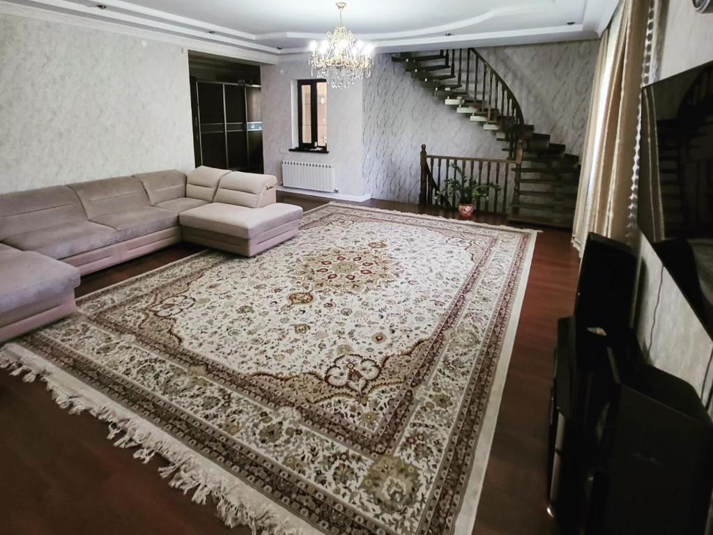 阿拉木图Almaty guest house的带沙发和地毯的客厅