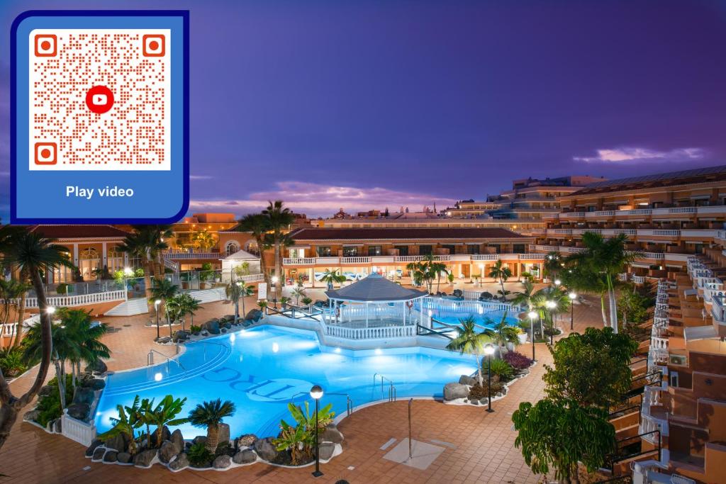 美洲海滩Tenerife South Apartments的夜间的度假村游泳池 ⁇ 染