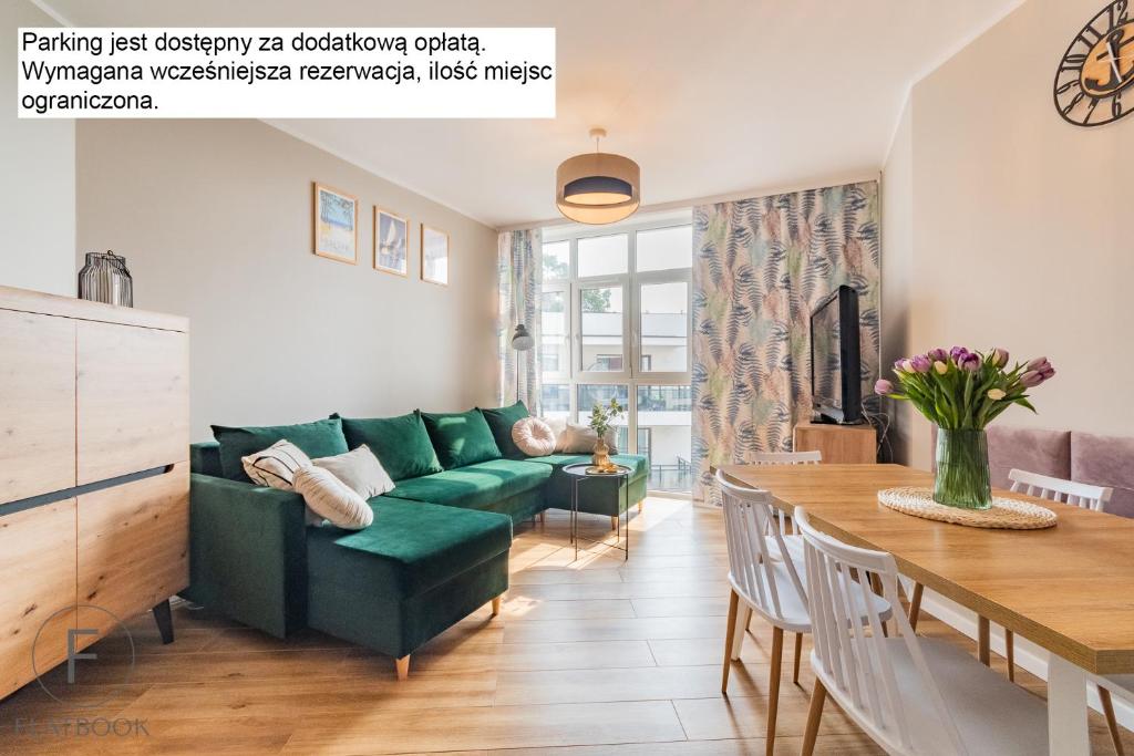 詹塔尔Flatbook Apartamenty - Jantar Bursztynowe Osiedle的客厅配有绿色沙发和桌子