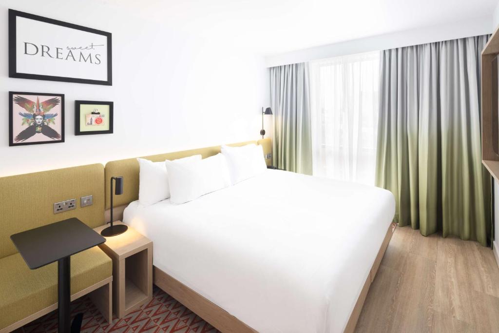 罗奇代尔Hampton By Hilton Rochdale的酒店客房设有一张白色大床和一个窗户。