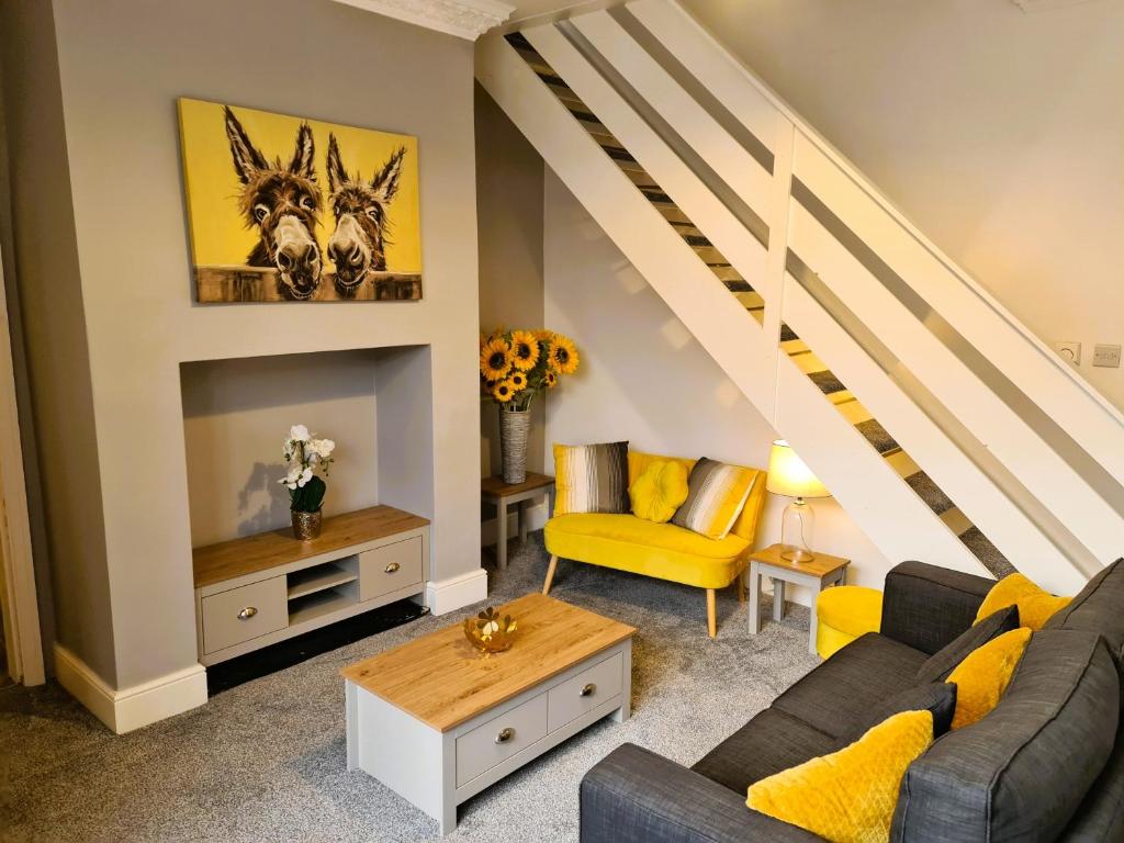 布莱克浦Tower Views 2 Bedroom House with Private Parking的客厅设有黄色家具和楼梯