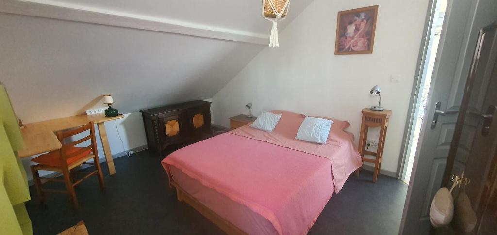 蒙贝利亚尔Cramiland - Chambre d'hôte chez nous的一间小卧室,配有粉红色的床和一张桌子