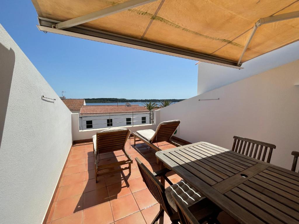 福尔内利斯Riera Rossello 2的阳台的天井配有木桌和椅子