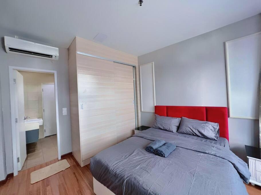 莎阿南Comfy Staycation 4PX with Free Parking, Direct Linked SOGO & Central I-CITY的一间卧室配有一张大床和红色床头板