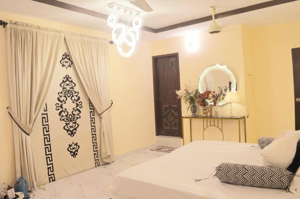 卡拉奇Charming Home banglow的卧室配有白色的床和镜子