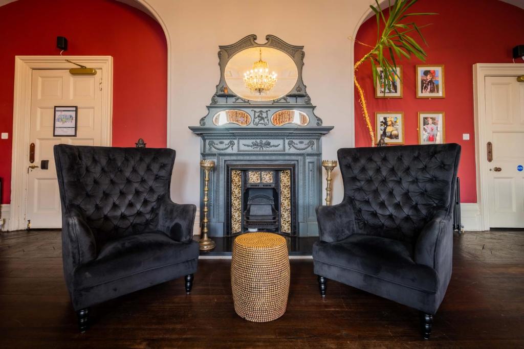 伦敦瑞士小屋朝圣者酒店的客厅配有两把椅子和壁炉
