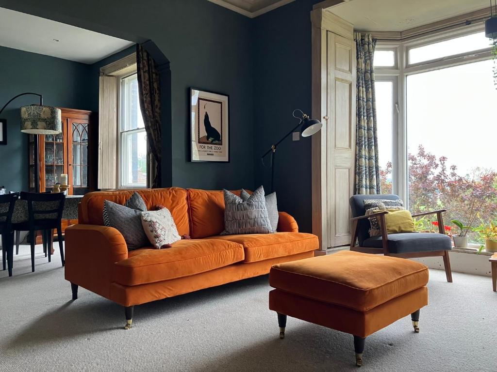 勒德洛Kennet House的客厅里设有一张橙色的沙发,拥有蓝色的墙壁