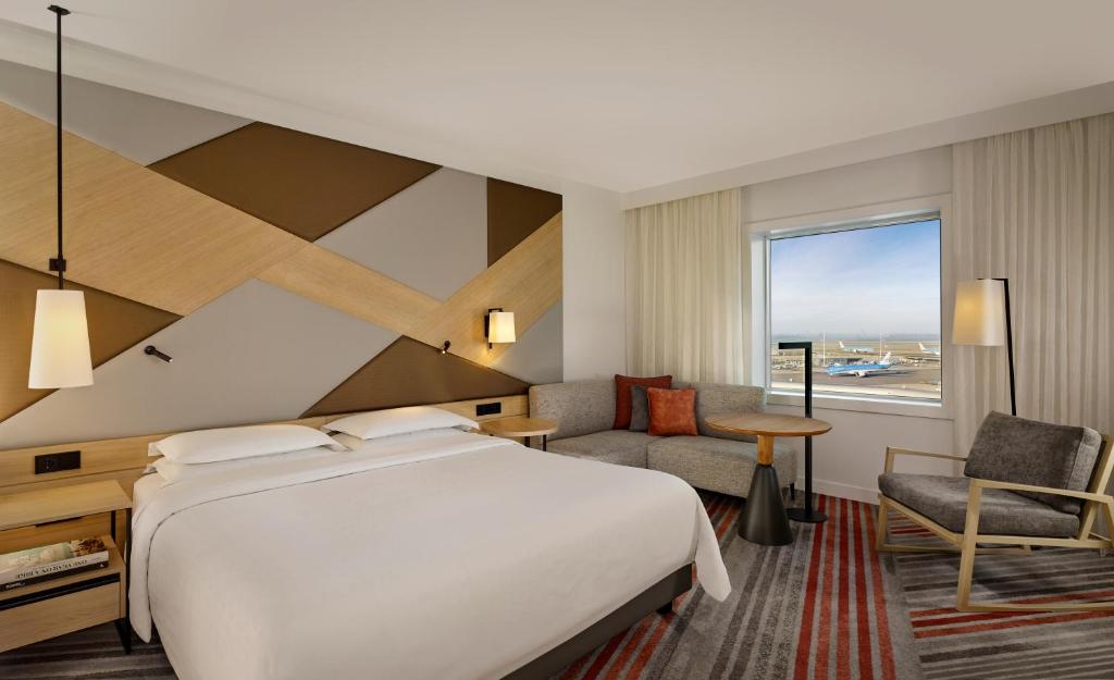 史基浦Sheraton Amsterdam Airport Hotel and Conference Center的配有一张床、一张书桌和一扇窗户的酒店客房