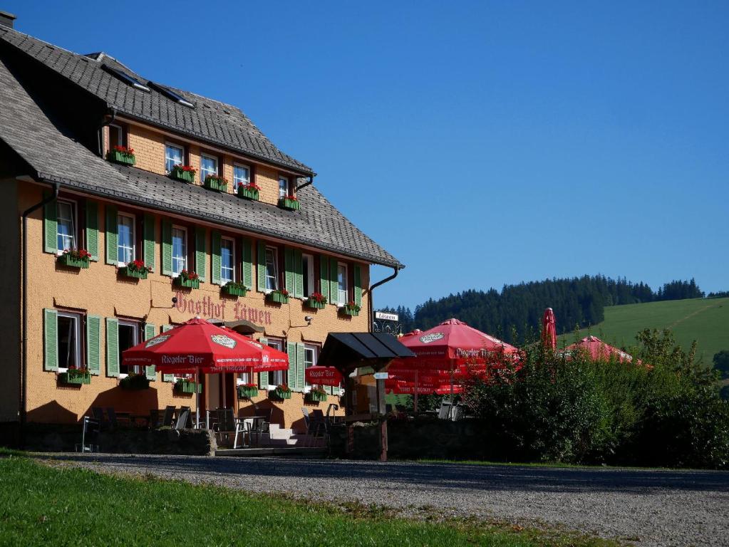 布莱特瑙Feriengasthof Löwen的前面有红伞的建筑