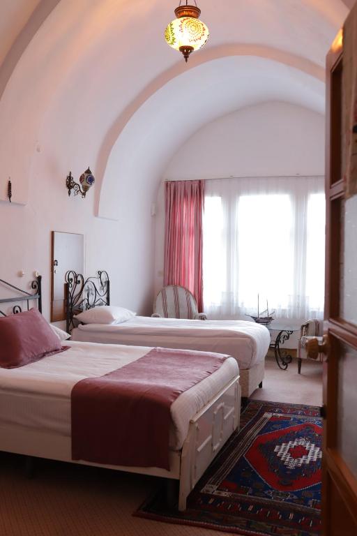 内夫谢希尔Cappadocia Landscape House的一间带两张床的卧室,位于带窗户的房间内