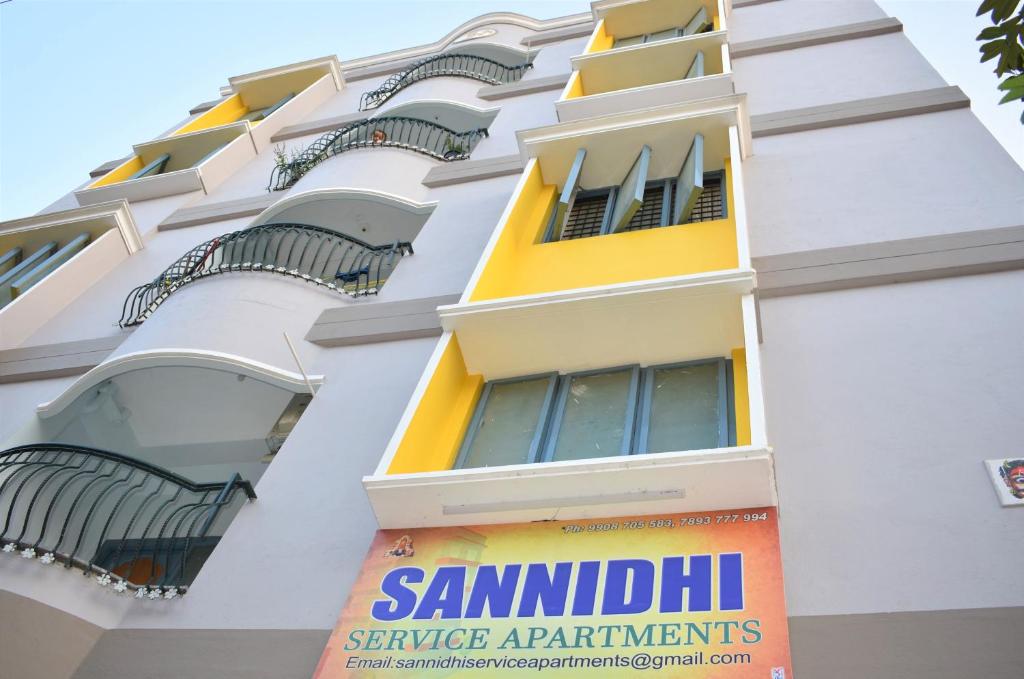 蒂鲁帕蒂Sannidhi Service Apartments的带阳台的建筑,上面有标志