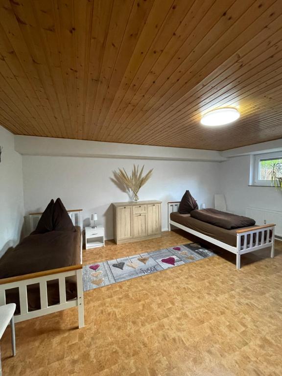 HeddesheimFerienwohnung Juco的一间卧室设有两张床和木制天花板