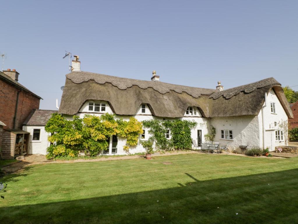 拉特沃思Millstone House的一座带茅草屋顶的大型白色房屋