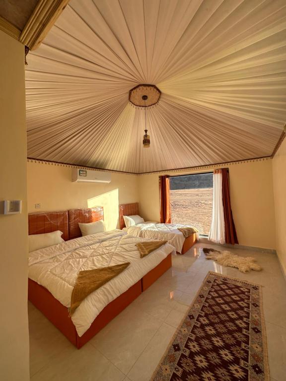 瓦迪拉姆Mountain Magic Camp Wadi Rum的一间卧室设有一张大床和一个大窗户