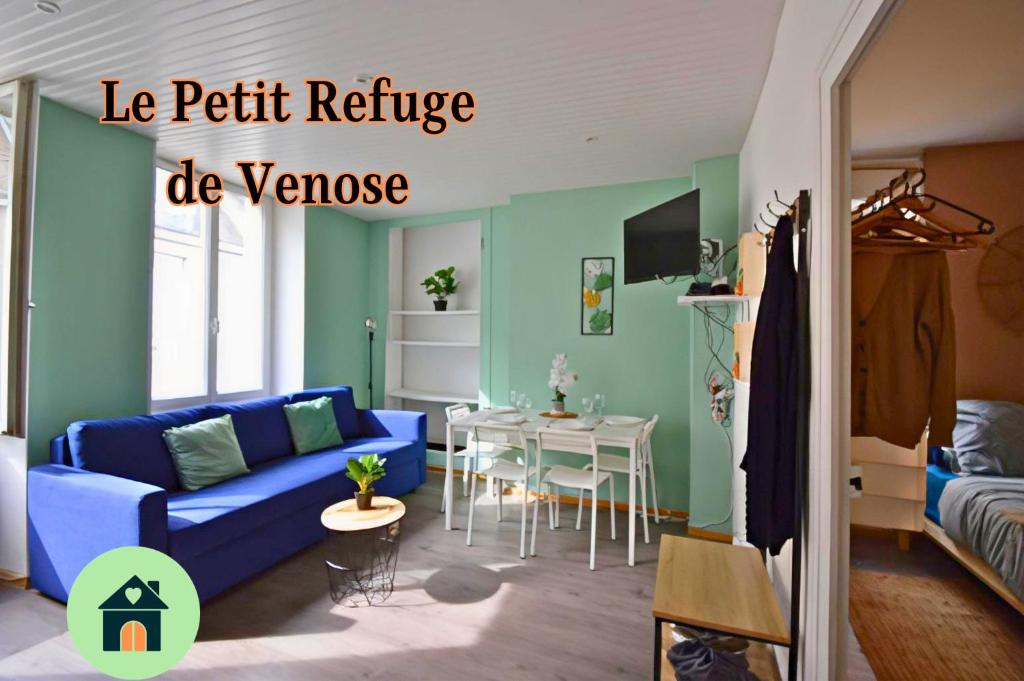 拉沙特尔Le Petit Refuge de Venose的客厅配有蓝色的沙发和桌子