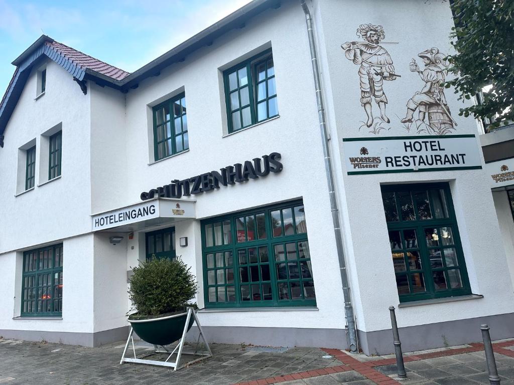 沃尔夫斯堡Hotel Schuetzenhaus Vorsfelde的白色建筑,标有酒店餐厅的标志