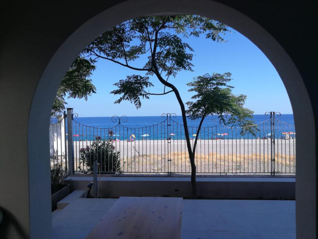马斯卡利Villa sul mare Dambra Apartment的拱门,从大楼内可欣赏到海滩景色