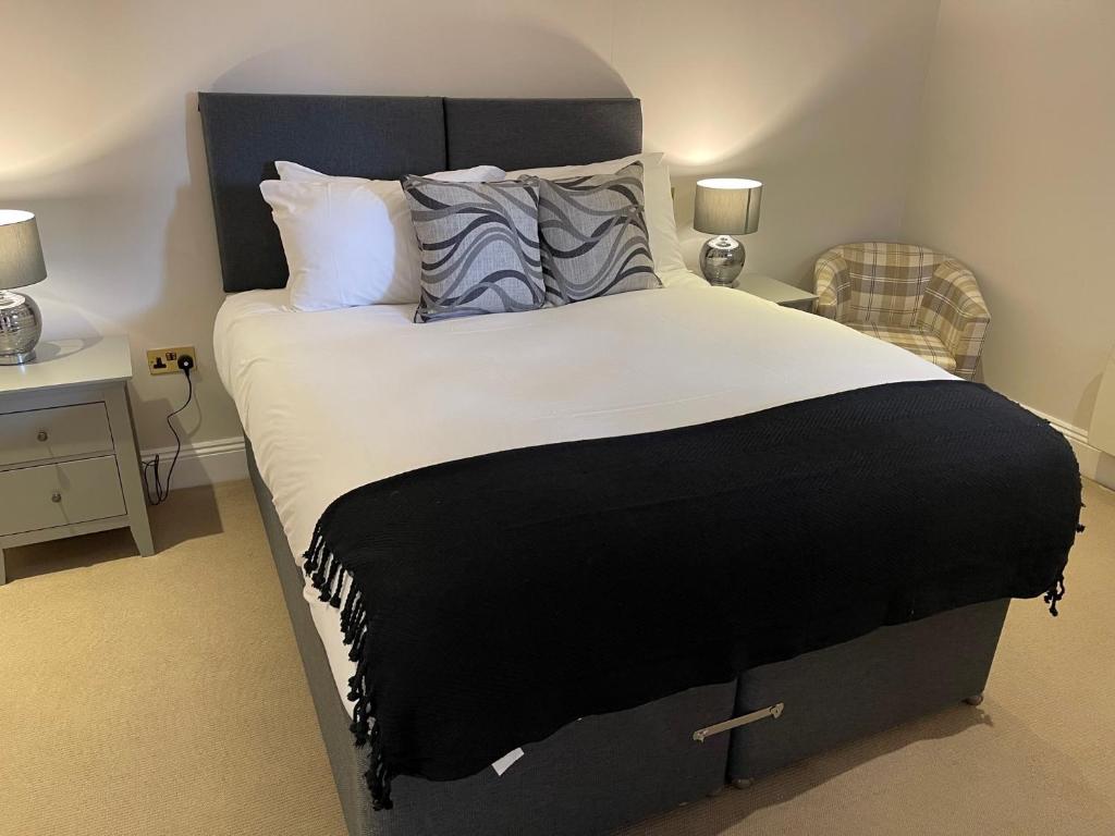 库克姆The Crown of Cookham的卧室配有一张带白色床单和枕头的大床。