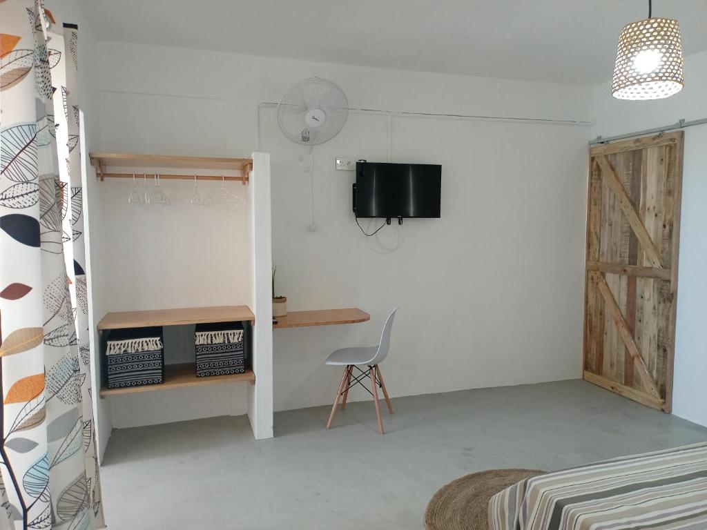 Rodrigues IslandIZAVA LODGE的一间带椅子、书桌和电视的房间
