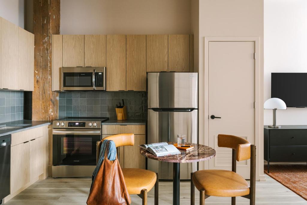 芝加哥Sonder The Burnham的厨房配有桌子和不锈钢冰箱。