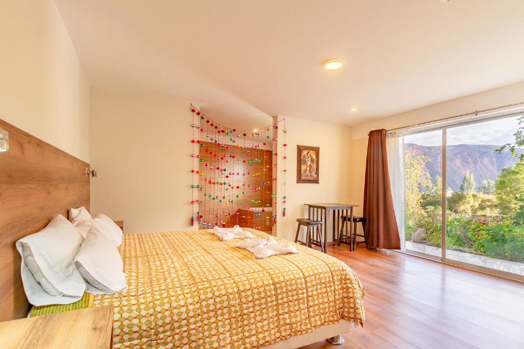 乌鲁班巴Valles Apartamentos Ecológicos VAE - Urubamba Cusco Perú的一间卧室设有一张床和一个大窗户